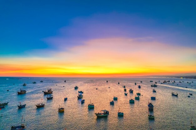 Foto vista aerea del villaggio di pescatori di mui ne nel cielo al tramonto con centinaia di barche ancorate per evitare tempeste