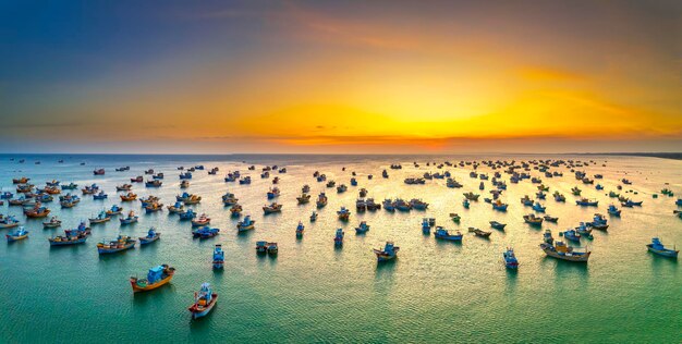 Foto vista aerea del villaggio di pescatori di mui ne nel cielo al tramonto con centinaia di barche ancorate per evitare tempeste