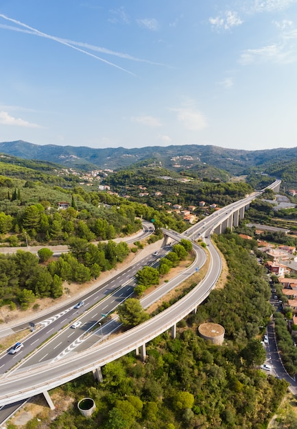 複数車線の高速道路を渡る村と森林の丘の上からの眺め（Autostrada dei Fiori  -  A10）Liguriaイタリア