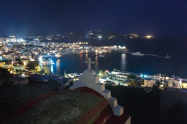 Foto vista aerea della città di mykonos, chora con il vecchio porto, case bianche, mulini a vento e chiese sull'isola mykonos, l'isola dei venti, di notte, grecia