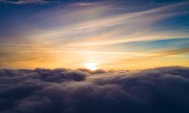 Aerial view Mystical gray winter clouds piled up against the backdrop of a golden sunset in the winter