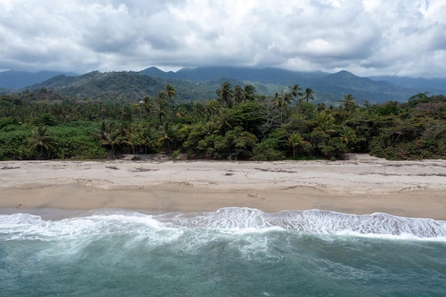Aerial view of nature hills and beach of Los Naranjos in Santa Marta by Tayrona National Park in Colombia