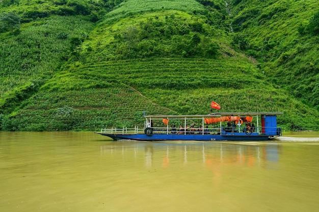 Foto veduta aerea del fiume nho que in una mattinata nebbiosa con la favolosa tonalità smeraldo è uno dei fiumi più belli del vietnam nordorientale la vista panoramica di un profondo canyon e di barche turistiche