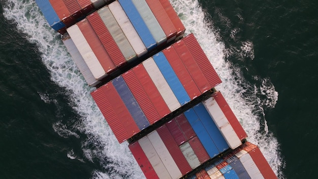 Фото Вид с воздуха на контейнеровоз, плывущий по морю, его массивный корпус рассекает воду, когда он перевозит грузы по всему миру корабль окружен бесконечными волнами