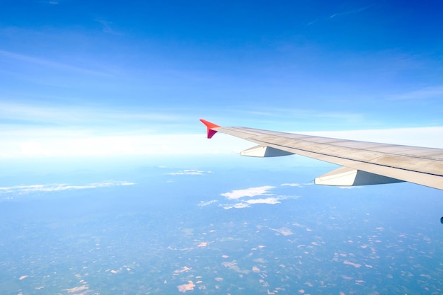 写真 青い空を背景に飛行機の翼を空から眺める