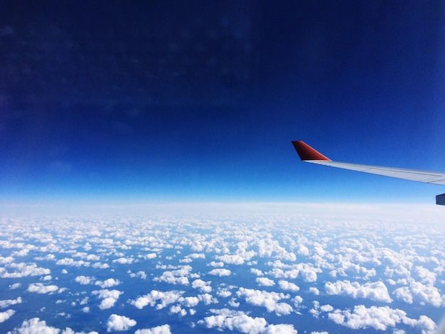 写真 青い空を背景に飛行機の翼を空から眺める