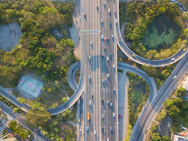 写真 樹木の中の道路で動く車の空中写真