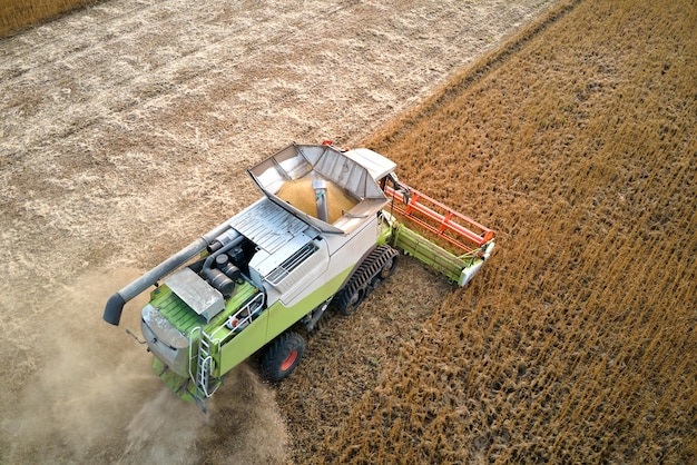 大規模な熟した小麦畑で収穫期に働くコンバインの航空写真農業の概念