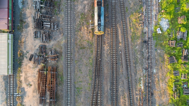 Фото Аэрофотоснимок тепловоза поезда и железнодорожные пути - вид сверху pov промышленной концептуальной сцены с поездами