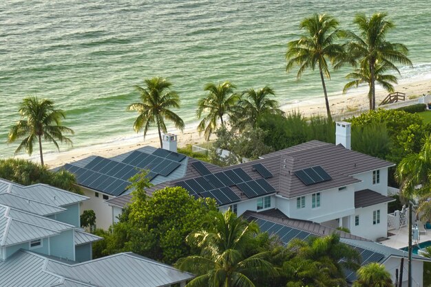 写真 クリーンな生態学的電気エネルギーを生成するための青い太陽光発電パネルを備えた高価なアメリカの建物の屋根の空撮退職所得の概念のための再生可能電力への投資