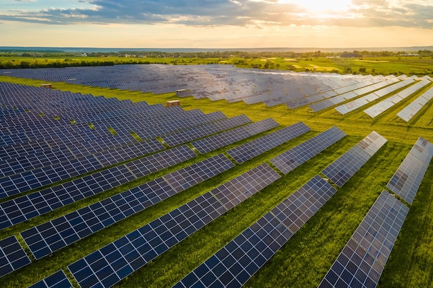 写真 クリーンな生態学的電気エネルギーを生成するための太陽光発電パネルの多くの列を備えた大規模で持続可能な発電所の航空写真。ゼロエミッションコンセプトの再生可能エネルギー。