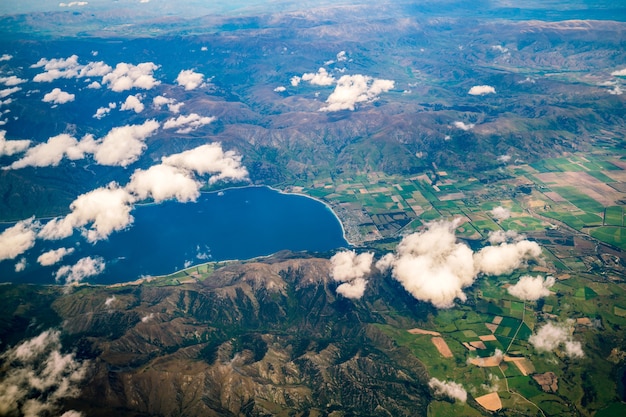 写真 クイーンズタウン、ニュージーランドの近くの山の上の飛行機からの山と湖の風景の航空写真