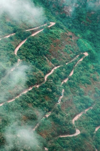 山の森林に覆われた蛇行道路の航空写真