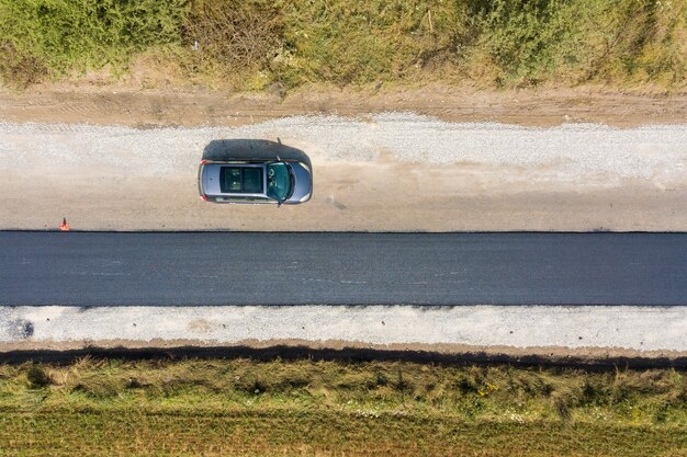 新しく敷設された黒いアスファルトレーンを備えた新しい道路建設の航空写真。