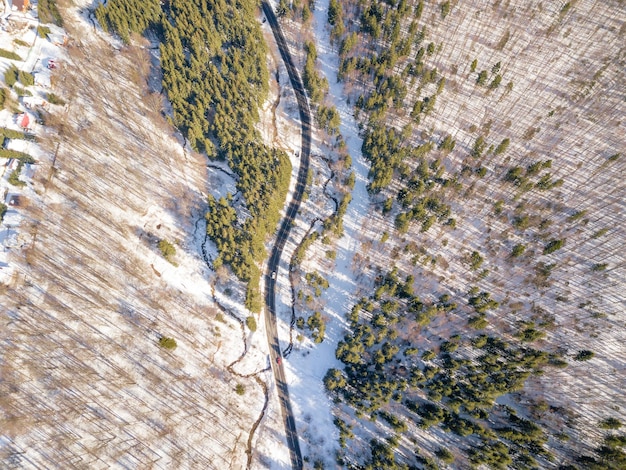 Фото Взгляд с воздуха на дорогу посреди леса зимой