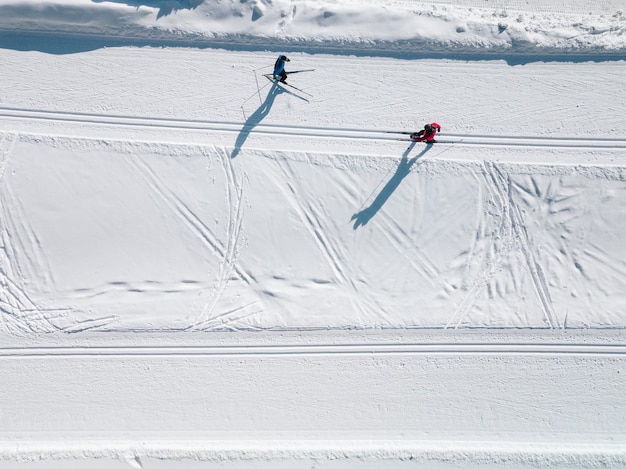 Фото Вид с воздуха на лыжные трассы в снегу мужчины катаются на лыжах в финляндии снято сверху