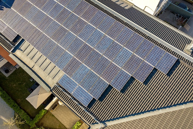 Вид с воздуха на солнечные фотоэлектрические панели на крыше жилого здания для производства чистой электроэнергии. концепция автономного жилья.