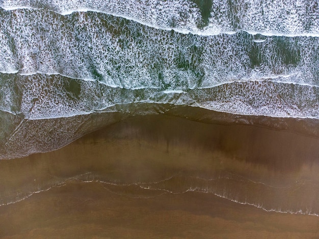Фото Вид с воздуха на морские волны, скользящие по песку