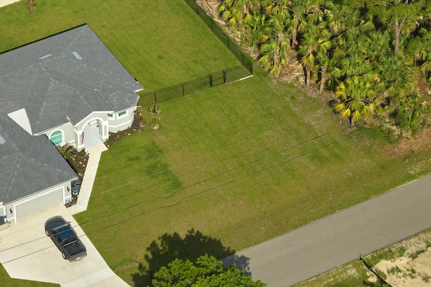 Фото Вид с воздуха на типичный современный американский частный дом с крышей, покрытой асфальтовой черепицей, и зеленой лужайкой во дворе