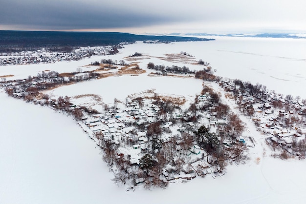 Фото Вид с воздуха на деревню посреди замерзшей бухты в зимний день после снегопада