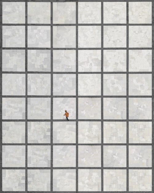 Фото Взгляд с воздуха на женщину, идущую по плиточному полу