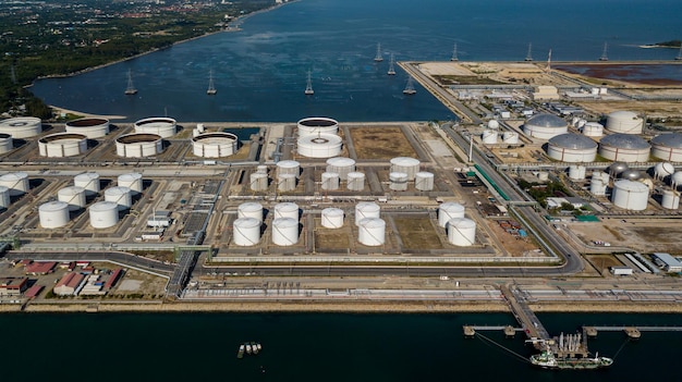 Aerial view oil terminal and coal power plant station in sea White oil storage tank chemical petroleum petrochemical refinery product Tanker ship at deep ocean seaport terminal
