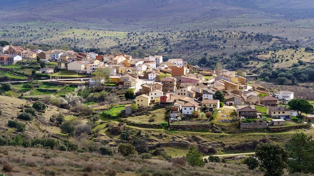 Aerial view of old town in the valley surrounded by mountains and green plants. Paredes Buitrago Madrid.