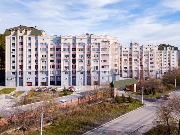 Aerial view of one entrance to white residential houses with parking cars in the city