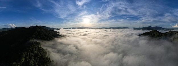 Фото Вид с воздуха панорама текущих туманных волн на горных тропических лесах изображение с высоты птичьего полета над облаками удивительный природный фон с облаками и горными вершинами в таиланде
