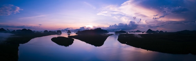 Aerial view panorama shot of beautiful lake against sunset or sunrise sky with mountain forest Landscape High angle view Dynamic aerial shot Amazing nature landscape view