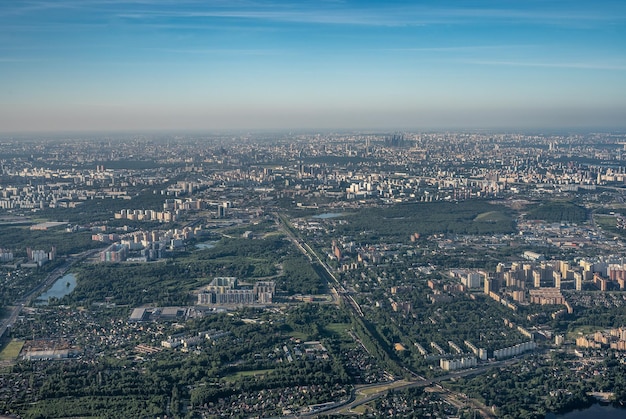 Aerial view photo from airplane of city and clear sky aerial\
photo of large city from an airplane window view of city of moscow\
through window from plane