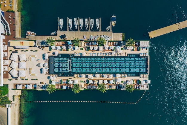 Aerial view pool with seaside yachts in dock rich life
