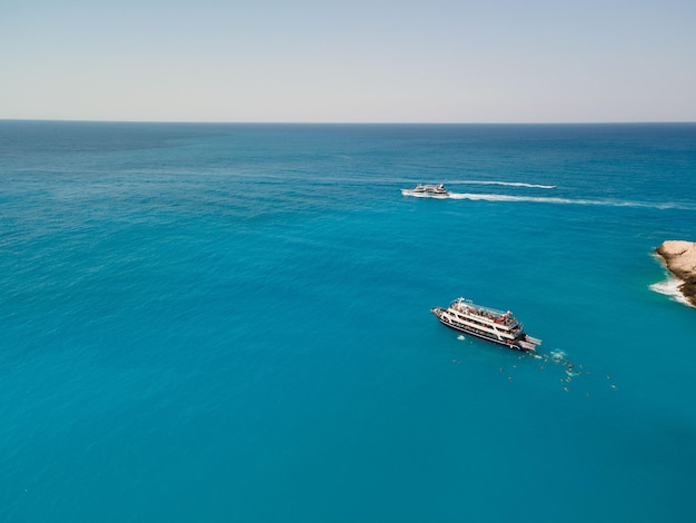 Aerial view of porto katsiki beach with cruise boat people having fun