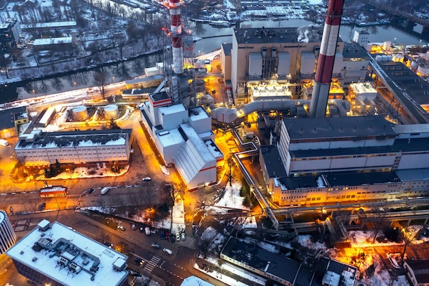 Вид с воздуха на электростанцию Вид на трубы градирни и здания вечером Ярко освещенные промышленные здания