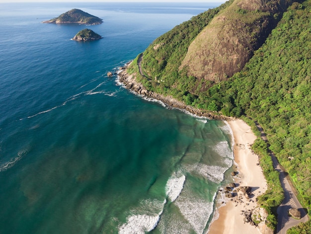 Aerial view of Prainha Beach, a paradise in the west side of Rio de Janeiro, Brazil. Big hills around. Sunny day at dawn. Greenish sea. Drone Photo.