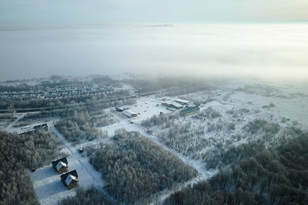 Aerial view of private homes with snow covered roofs in rural\
suburbs town area in cold winter