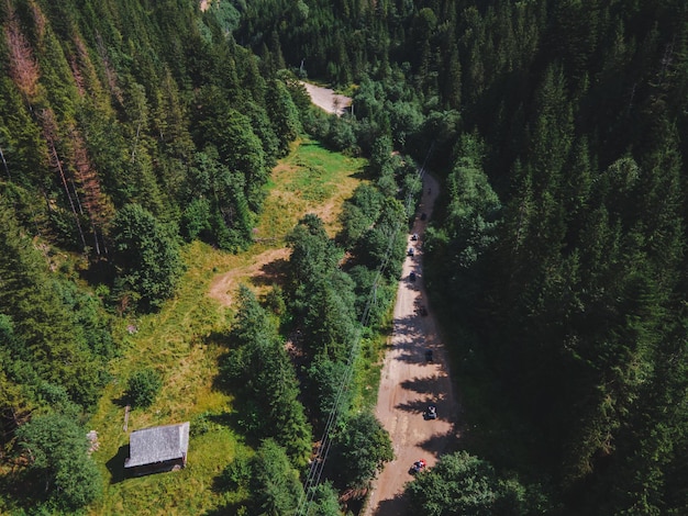 Aerial view of quad bike riders at mountain trail road copy space