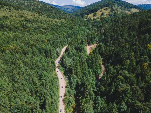 Aerial view of quad bike riders at mountain trail road copy space