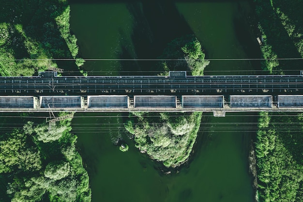 Aerial view of railway railroad tracks and cargo train over the\
river