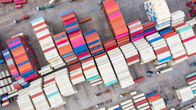 Aerial view reach stackers move containers at a freight terminal, industrial container terminal and storage containers area.