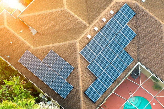 Aerial view of regular american home roof with blue solar\
photovoltaic panels for producing clean ecological electric energy\
renewable electricity with zero emission concept