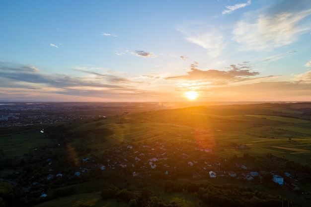 Aerial view of residential houses in suburban rural area at sunset.