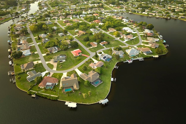 Aerial view of residential suburbs with one storey houses located near wildlife wetlands with green tropical vegetation on sea shore Living close to nature in warm climate concept