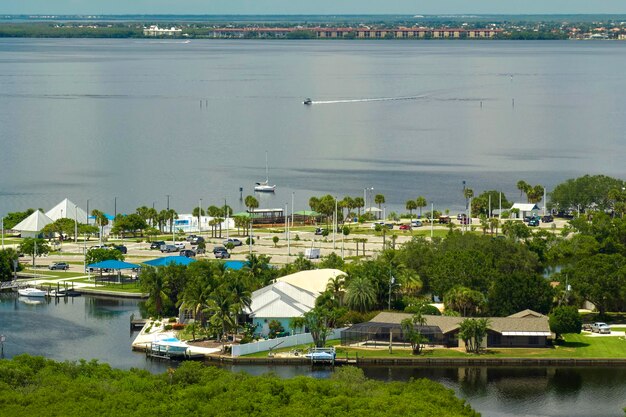 Aerial view of residential suburbs with private homes located near wildlife wetlands with green vegetation on sea shore Living close to nature concept