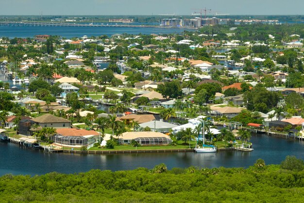 Aerial view of residential suburbs with private homes located near wildlife wetlands with green vegetation on sea shore Living close to nature concept