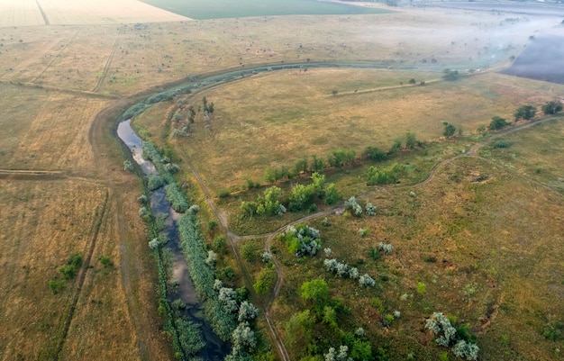 Aerial view over the river stream. Cloudy summer day.