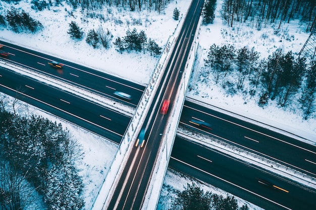 Aerial view of road amidst snow covered field