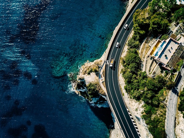 山と海または海に沿って進む道路の航空写真上からのドローン写真