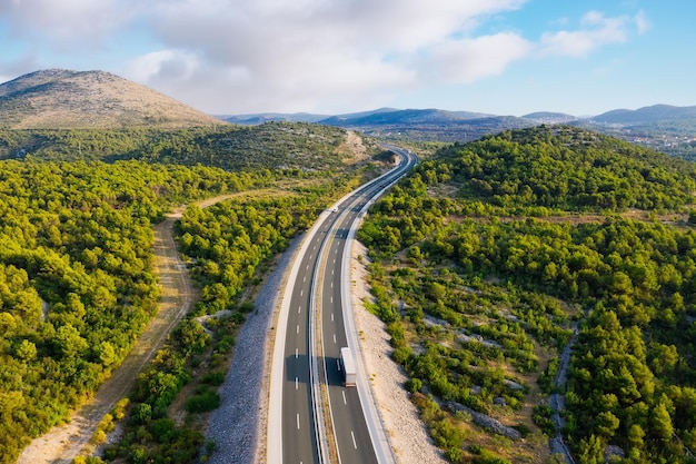 Aerial view on road Highway throu mountain valley View from a drone Natural landscape in summer time from air Travel and vacation Transportation image