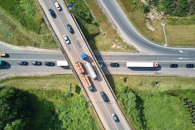 Aerial view of road intersection with fast moving heavy traffic on city streets Uban transportation during rush hour with many cars and trucks